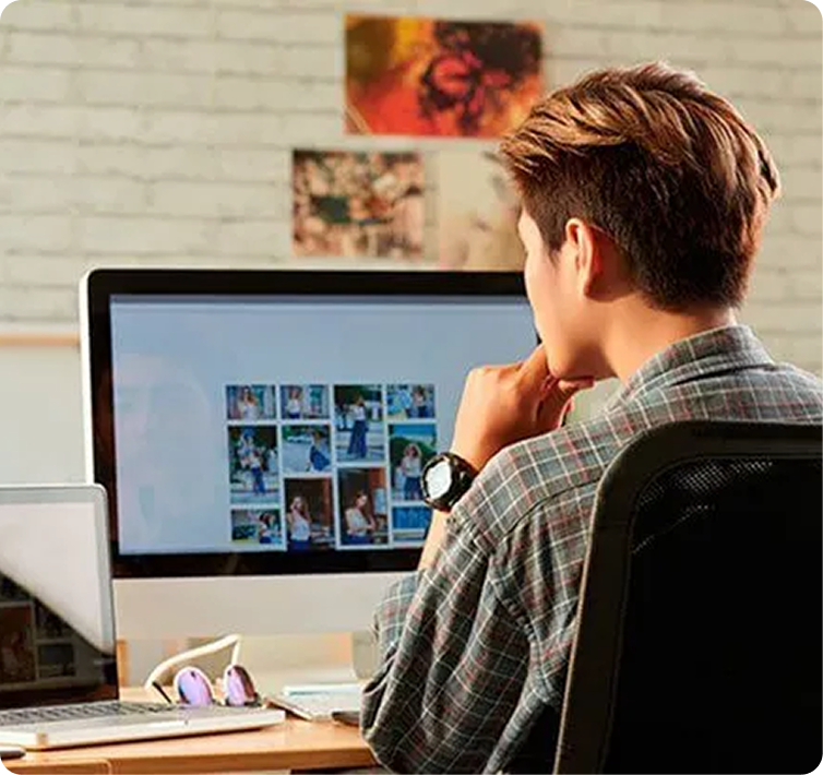 Editor reviewing layouts and images on a desktop computer
