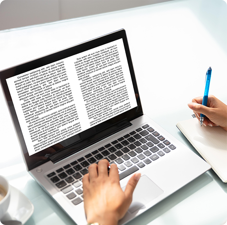 Writer working on a laptop with a book displayed on the screen