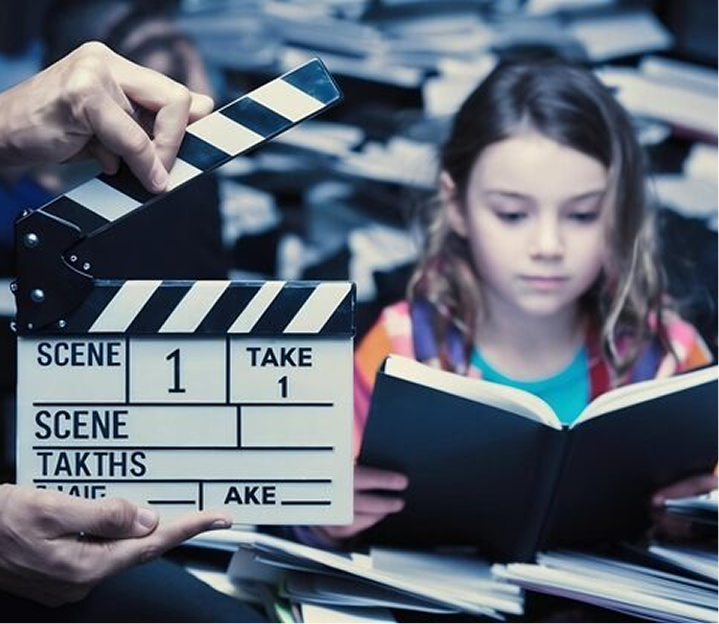 Film clapboard alongside a young reader holding an open book